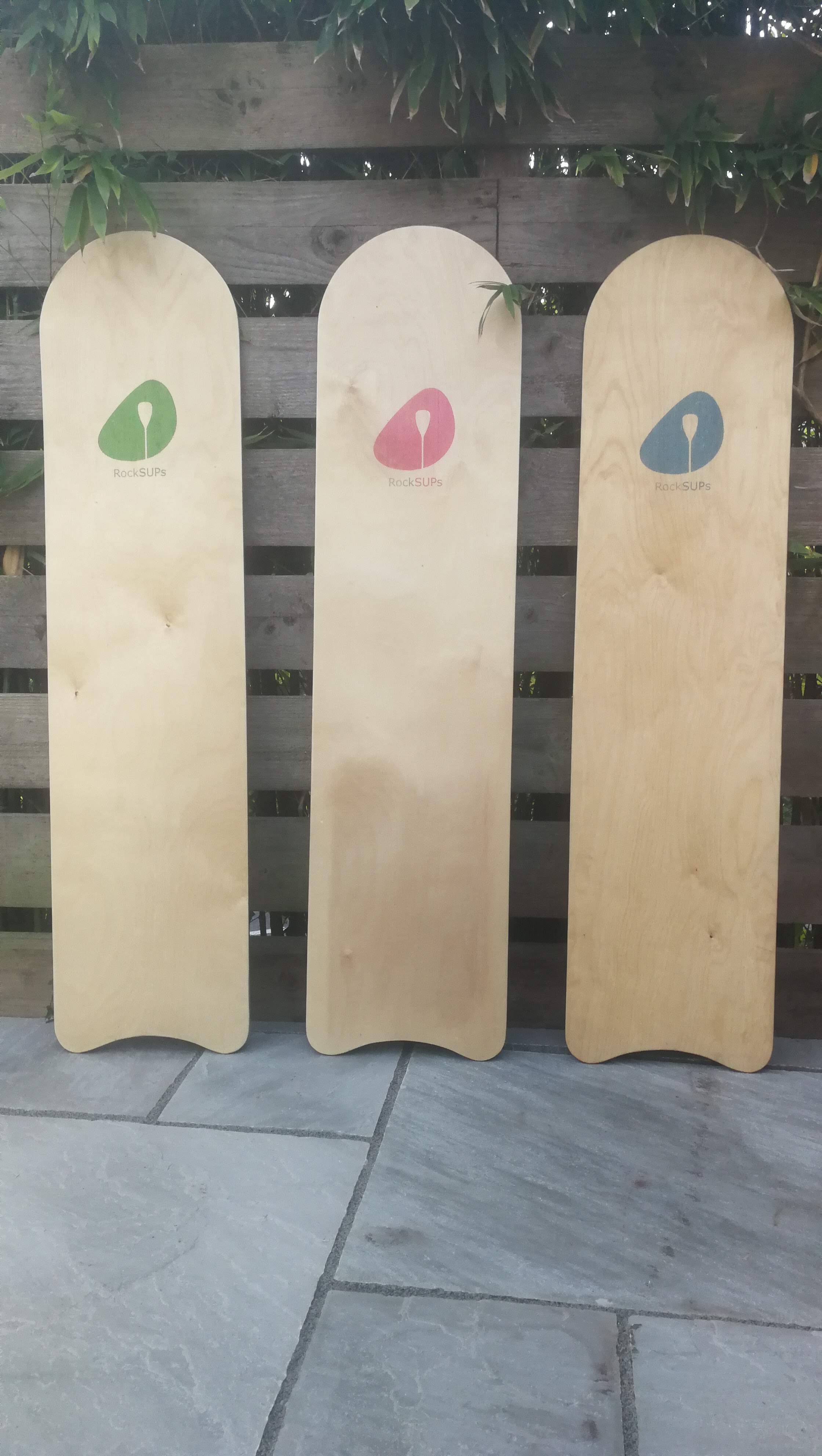 Photo of 3 belly boards displaying the logo colours
